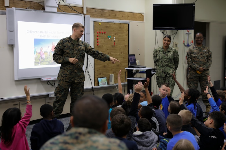 Navy Lt. Michael J. Lawrence, left, gives instructions to students from Kinser Elementary School during a presentation Feb. 5, 2019 on Camp Kinser, Okinawa, Japan. Sailors from Naval clinics in Okinawa held a presentation to promote oral health awareness during National Children’s Dental Health Month. Lawrence, a general dentist with Branch Dental Clinic Evans, 3rd Dental Battalion, 3rd Marine Logistics Group, is a native of Troutdale, Oregon. (U.S. Marine Corps photo by Lance Cpl. Armando Elizalde)