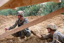 Cpl. William Vincent, left, and Lance Cpl. Bryce Taft inspect damage on a bridge structure Feb. 7, 2019 at Camp Hansen, Okinawa, Japan. Marines with Medium Girder Bridge Platoon, Bridge Company, 9th Engineer Support Battalion, 3rd Marine Logistics Group, repaired then disassembled a bridge they constructed earlier that week to further train in bridge building. Vincent, a combat engineer team leader with MGB Plt., Bridge Co., 9th ESB, 3rd MLG, is a native of Springfield, Illinois. Taft, a combat engineer fire team leader with MGB Plt., Bridge Co., 9th ESB, 3rd MLG, is a native of Maricopa, Arizona. (U.S. Marine Corps photo by Lance Cpl. Ryan Harvey)