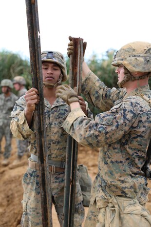 Sgt. Thiavadem Thang, left, and Lance Cpl. Bryce Taft separate stakes used to barricade a bridge from being used Feb. 7, 2019 at Camp Hansen, Okinawa, Japan. Marines with Medium Girder Bridge Platoon, Bridge Company, 9th Engineer Support Battalion, 3rd Marine Logistics Group, repaired then disassembled a bridge they constructed earlier that week to further train in bridge building. Thang, platoon guide with MGB Plt., Bridge Co., 9th ESB, 3rd MLG, is a native of Dallas, Texas. Taft, a combat engineer fire team leader with MGB Plt., Bridge Co., 9th ESB, 3rd MLG, is a native of Maricopa, Arizona. (U.S. Marine Corps photo by Lance Cpl. Ryan Harvey