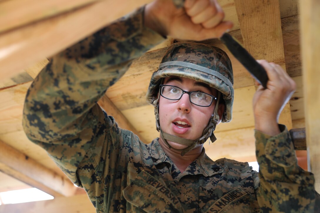 Cpl. Alexander Reverski removes an nail from a support beam during bridge deconstruction Feb. 7, 2019 at Camp Hansen, Okinawa, Japan. Marines with Medium Girder Bridge Platoon, Bridge Company, 9th Engineer Support Battalion, 3rd Marine Logistics Group, practiced repairing and disassembling bridges to further train in bridge building. Reverski, a combat engineer team leader with MGB Plt., Bridge Co., 9th ESB, 3rd MLG, is a native of Glen Burnie, Maryland. (U.S. Marine Corps photo by Lance Cpl. Ryan Harvey)