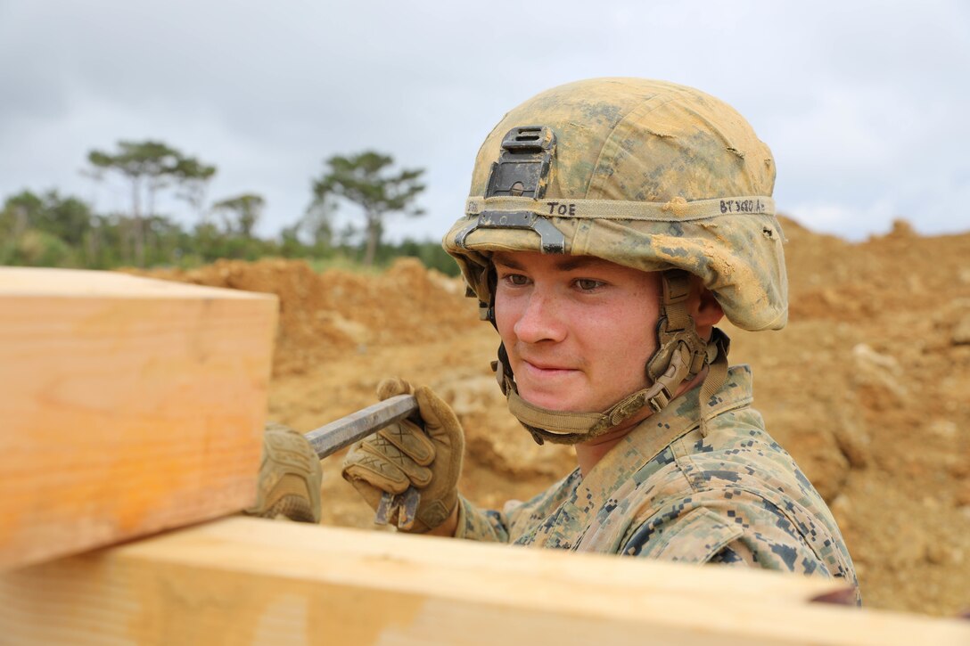 Lance Cpl. Bryce Taft uses a crowbar to pry a 4x4 piece of wood from a support beam Feb. 7, 2019 at Camp Hansen, Okinawa, Japan. Marines with Medium Girder Bridge Platoon, Bridge Company, 9th Engineer Support Battalion, 3rd Marine Logistics Group, repaired then disassembled a bridge they constructed earlier that week to further train in bridge building. Taft, a combat engineer fire team leader with MGB Plt., Bridge Co., 9th ESB, 3rd MLG, is a native of Maricopa, Arizona. (U.S. Marine Corps photo by Lance Cpl. Ryan Harvey)