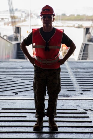 Cpl. David Vanpatton waits to ground guide a vehicle onto the ramp of the U.S.N.S. Pililaau (TAKR-304) during a maritime prepositioning force (MPF) offload for Cobra Gold 19 Feb. 3, 2019 at Laem Chabang Comercial Port, Thailand. The Pililaau is a Marine Corps MPF ship used to deliver Marine assets to areas in the Indo-Pacific region. Vanpatton is an electrical optical ordnance repairer with Combat Logistics Detachment 332, Combat Logistics Regiment 3, 3rd Marine Logistics Group, is a native of Riverside, California. (U.S. Marine Corps photo by Cpl. Jamin M. Powell)
