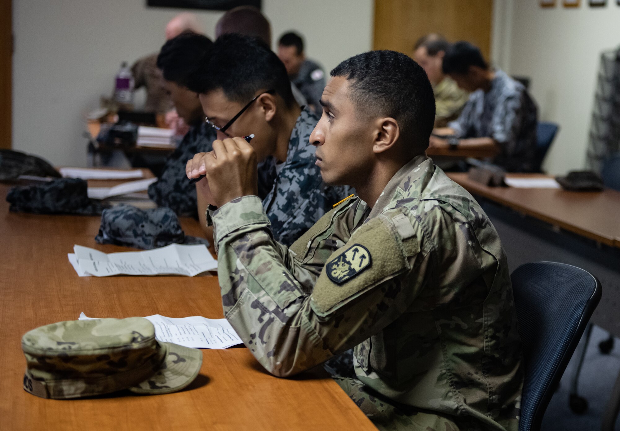 Japan Air Self-Defense Force Airmen and U.S. service members listen to a briefing Nov. 19, 2018, during the 2018 Bilateral Exchange at Kadena Air Base, Japan. The event included professional enhancement seminars, physical training, a tour of an MC-130H Combat Talon II, an infiltration and exfiltration demonstration, a historical tour and team building exercises. (U.S. Air Force photo by Staff Sgt. Micaiah Anthony)
