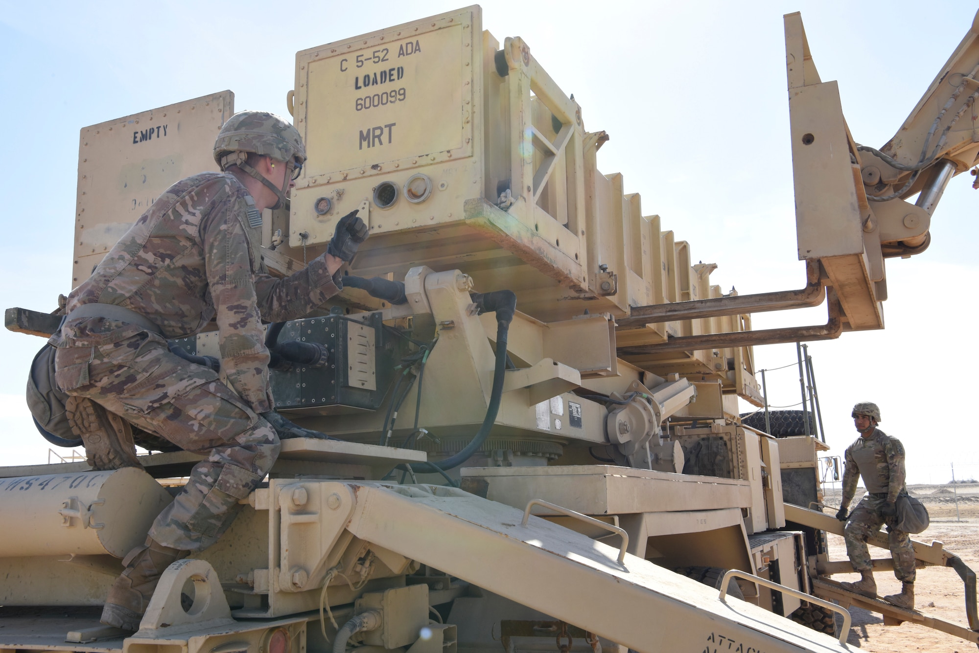 Specialist Tevin Howe, Bravo Battery, 1st Battalion, 43rd Air Defense Artillery Regiment Patriot launcher enhanced operator and maintainer crew member 4 signals for reload, while Specialist Eduardo Martinez, 1-43 ADA Patriot launcher enhanced operator and crew member 2, watches during training at Al Dhafra Air Base, United Arab Emirates, Jan. 12, 2019.