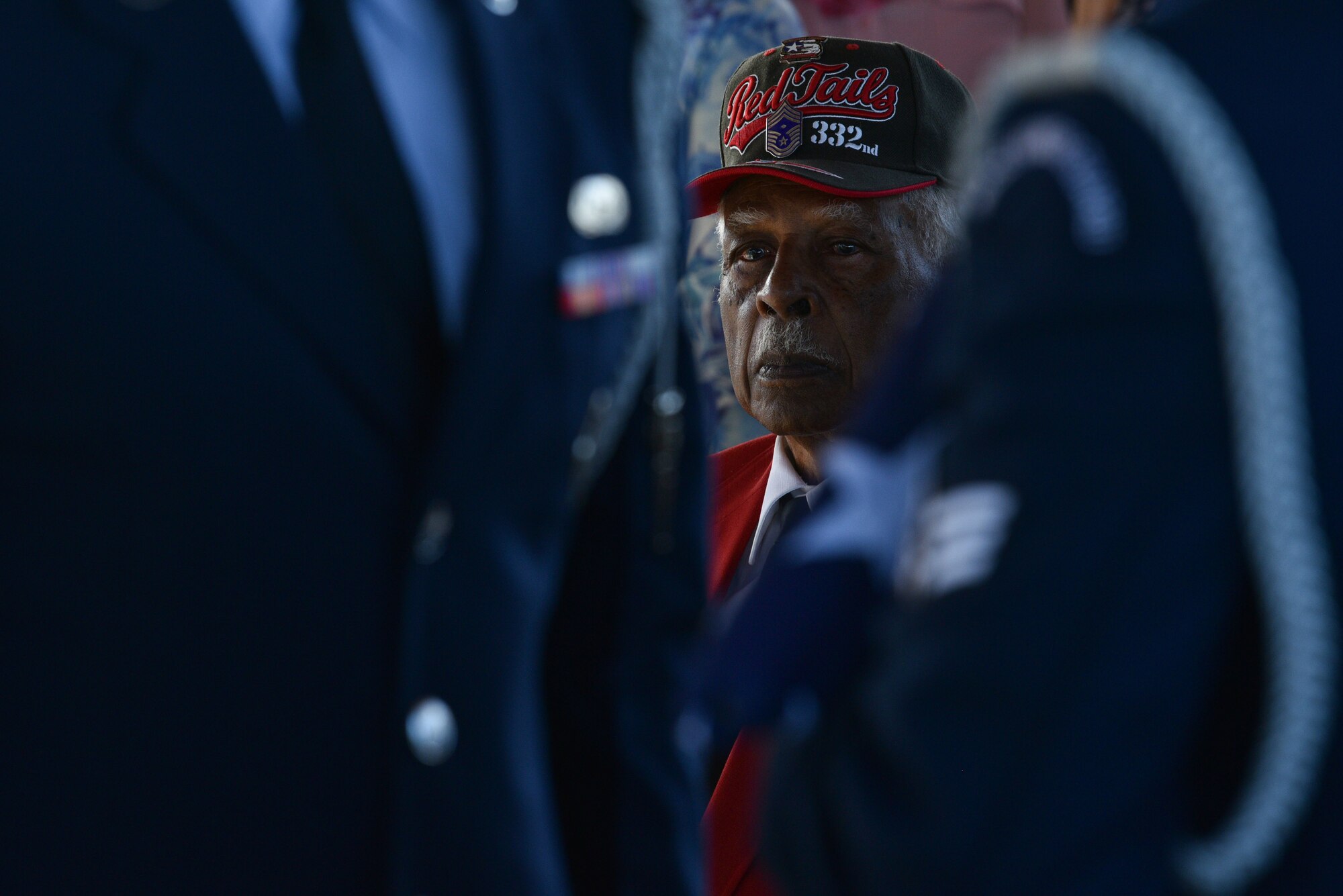 A Tuskegee Airmen chapter member watches Patrick Air Force Base Honor Guard Airmen present the colors during a Tuskegee Airman funeral, Feb. 7, 2019 at Cape Canaveral National Cemetery in Mims, Fla. Edwin Cowan, Tuskegee Airman, was laid to rest with his wife with military honors. (U.S. Air Force photo by Airman 1st Class Dalton Williams)
