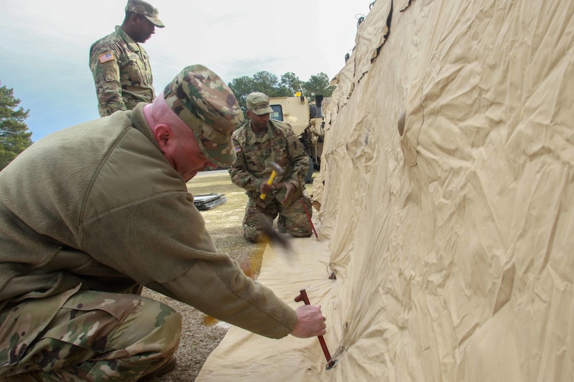 Soldiers with the 206th Digital Liaison Detachment, S.C. U.S. Army Reserves, hammer stakes in the ground to support a field tent during a Command Post Exercise at McCrady Training Center, S.C., Feb. 9, 2019. They joined members of the 151st Expeditionary Signal Battalion, S.C. National Guard, and members of the 2503rd DLD, U.S. Army Central. The training provided an opportunity for these three different Army components to work with the total Army concept, establish connectivity and test their Mission Command Systems.