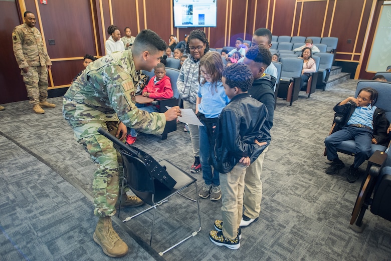 Senior Airman Emanuel Leon–Santiago, 42nd Operational Support Squadron air traffic controller, demonstrates how air traffic controllers speak to pilots flying in their airspace to a group of students from Thelma S. Morris Elementary School Feb. 5, 2019, Maxwell Air Force Base, Alabama. Students in grades three through five had an opportunity to visit the 42nd OSS and meet the Airmen who make the mission happen. (U.S. Air Force photo by Senior Airman Alexa Culbert)