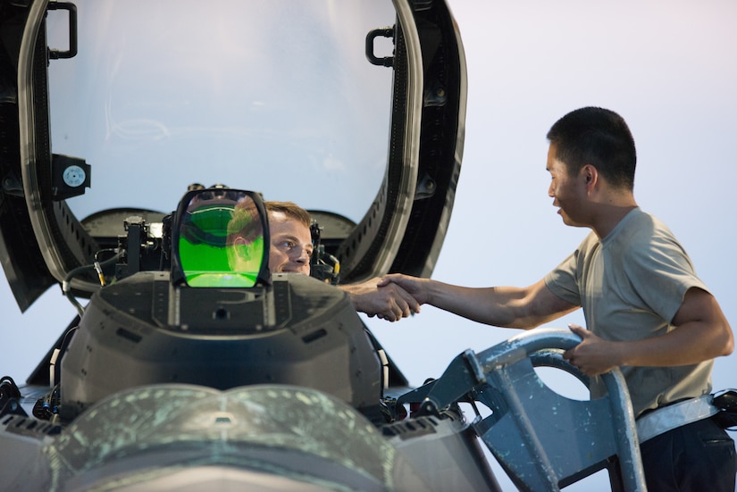 U.S. Air Force Airman 1st Class Andy Luong, 1st Aircraft Maintenance Squadron crew chief, shakes hands with a 94th Fighter Squadron pilot prior to his departure from Joint Base Langley-Eustis, Va., July 11, 2017.