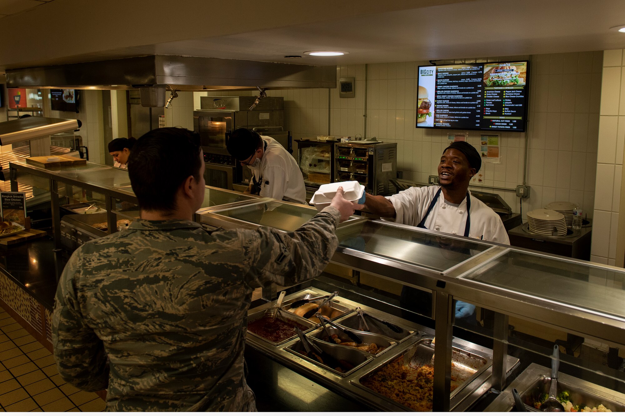 James Frierson, a cook from the Hangar 97 Dining Facility, hands food to a customer, Jan. 10, 2019 at Altus Air Force Base, Okla.