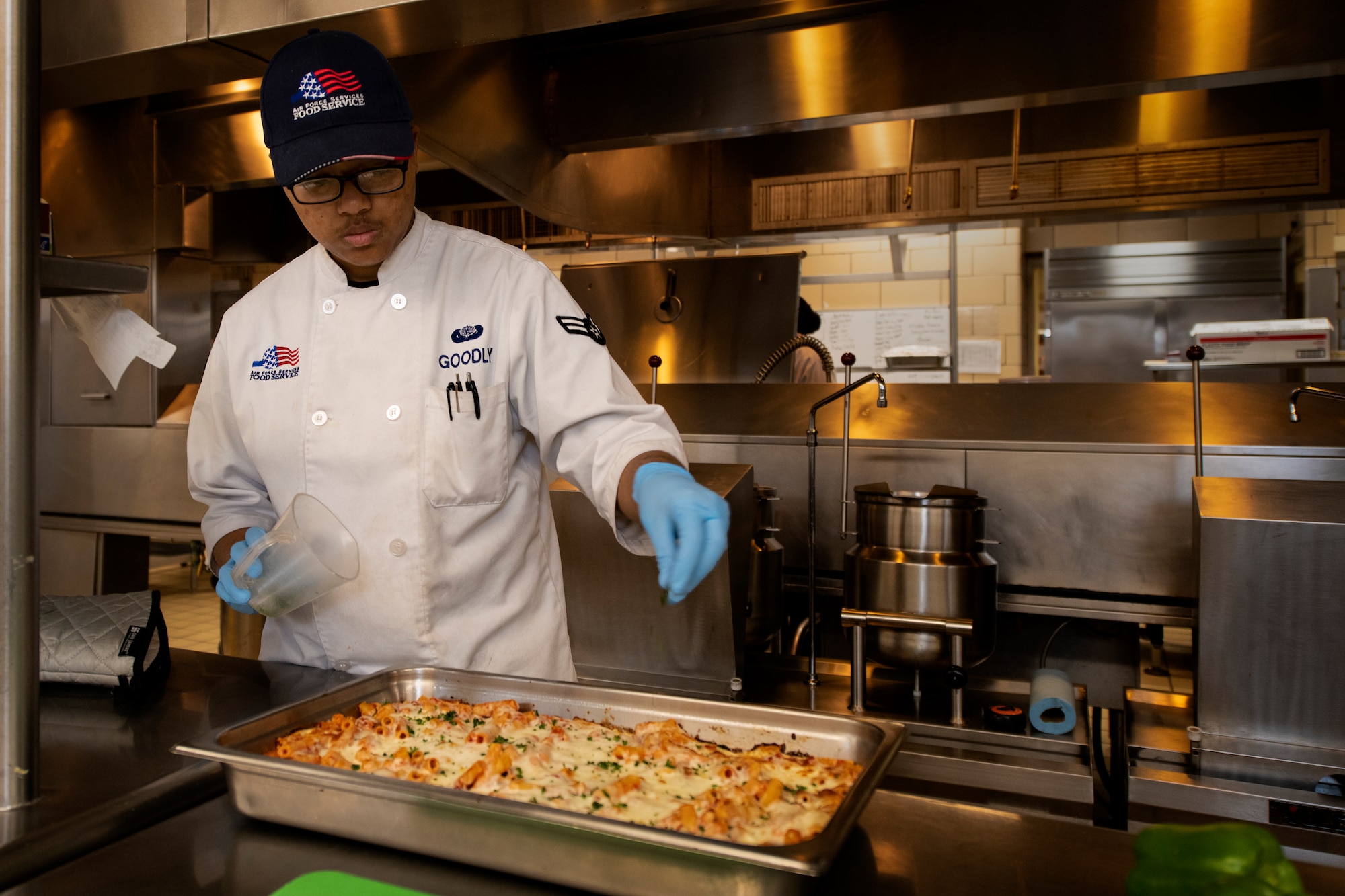 Airman 1st Class Joy Goodly, food services specialist assigned to the 97th Force Support Squadron Hangar 97 Dining Facility, prepares a pasta dish, Jan. 10, 2019 at Altus Air Force Base, Okla.