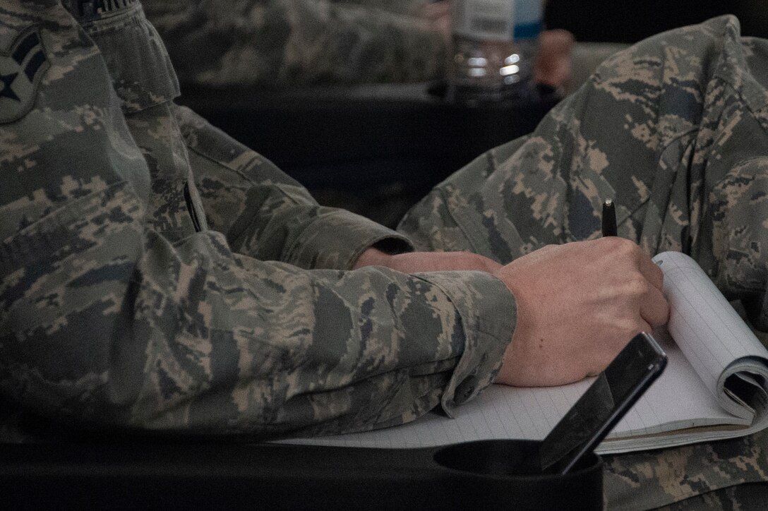 A participant of the Enhancing Human Capitol seminar takes notes of the information being presented