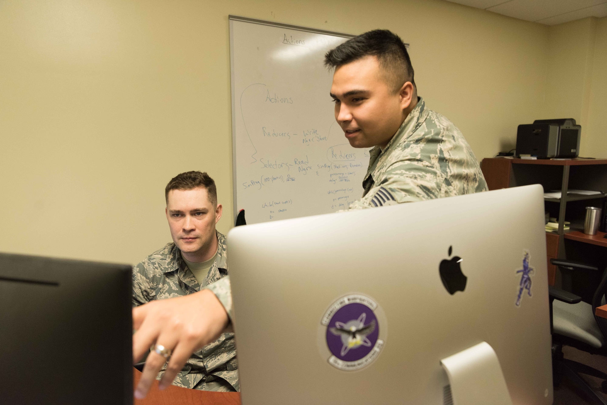 U.S. Air Force Tech. Sgt. Christopher Sills, 18th Communication Squadron programmer, and Staff Sgt. Alexander Nestle, 18th CS software development supervisor, work on LodgeNET, a contingency lodging application on Feb. 12, 2019 at Kadena Air Base, Japan. LodgeNET provides real-time contingency statistics in one collaborative platform, and consolidates data 99% faster than manual input.