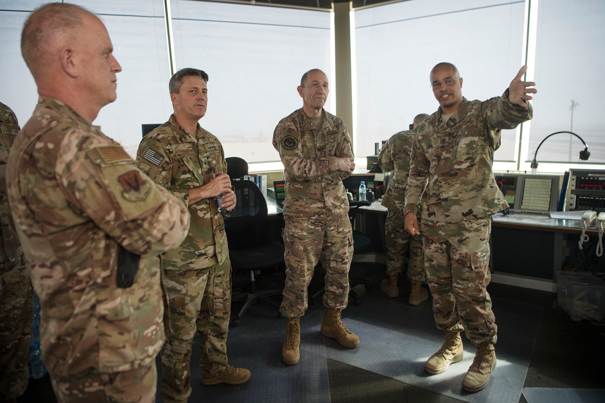 Gen. Mike Holmes, commander of Air Combat Command, Brig. Gen Jason Armagost, 379th Air Expeditionary Wing commander (center left), and Chief Master Sgt. Frank Batten, ACC command chief (left), listen to a control tower mission briefing from Maj. Donald Roley, 379th Expeditionary Operations Support Squadron, during an ACC leadership visit Feb. 11, 2019, at Al Udeid Air Base, Qatar.