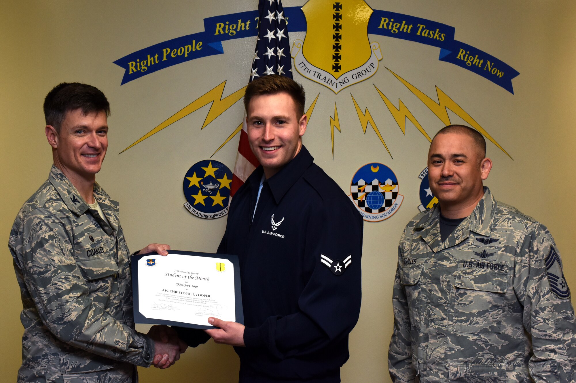 U.S. Air Force Col. Thomas Coakley, 17th Training Group commander, presents the 315th Training Squadron Student of the Month award to Airman 1st Class Christopher Cooper, 315th TRS student, at the Brandenburg Hall on Goodfellow Air Force Base, Texas, Feb. 8, 2019. The 315th TRS’s vision is to develop combat-ready intelligence, surveillance and reconnaissance professionals and promote an innovative squadron culture and identity unmatched across the U.S. Air Force. (U.S. Air Force photo by Airman 1st Class Zachary Chapman/Released)