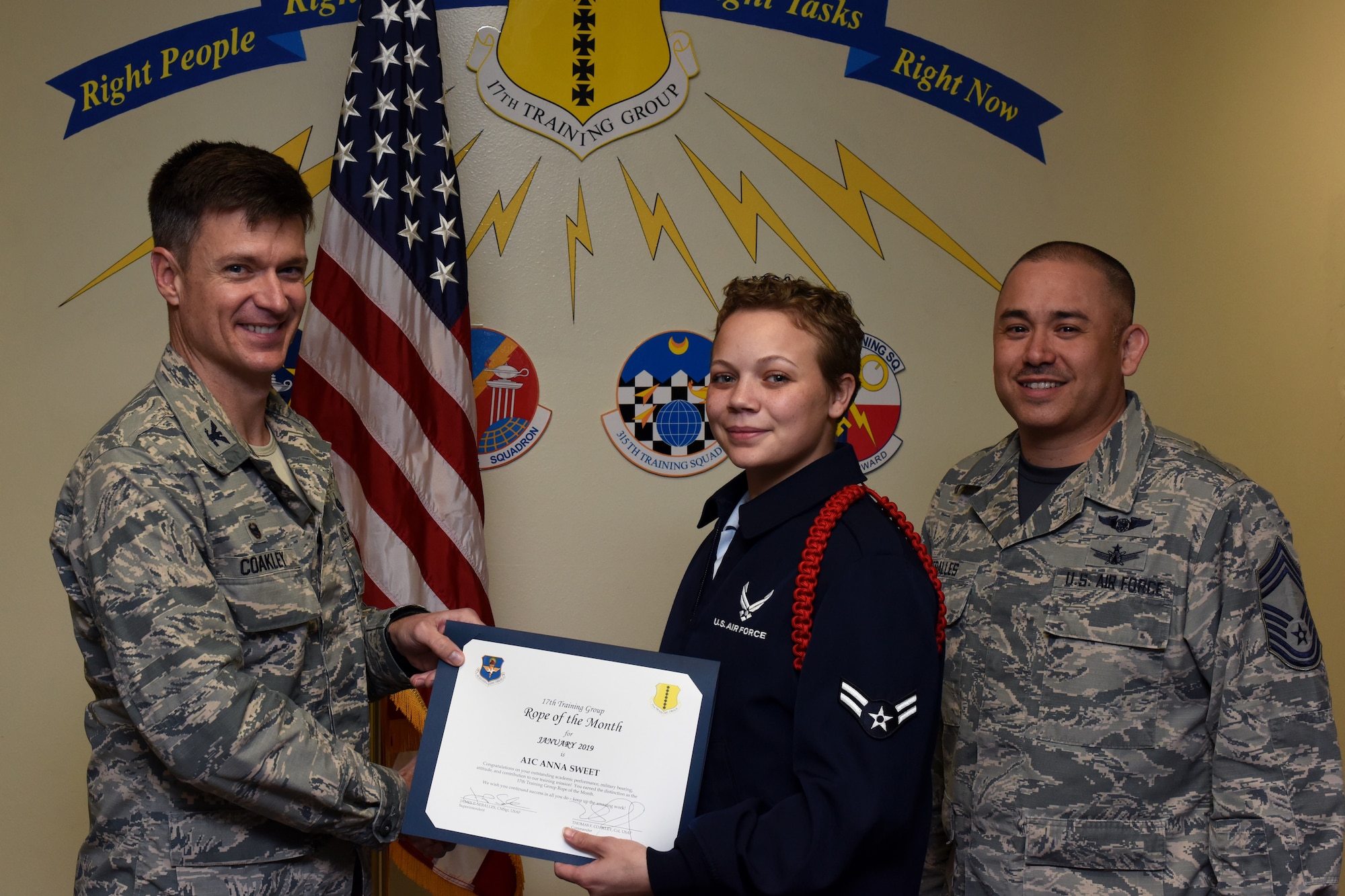 U.S. Air Force Col. Thomas Coakley, 17th Training Group commander, presents the Rope of the Month award to Airman 1st Class Anna Sweet, 315th Training Squadron student. Military Training Leaders present ropes to Airmen who display exceptional leadership qualities to lead their peers. (U.S. Air Force photo by Airman 1st Class Zachary Chapman/Released)