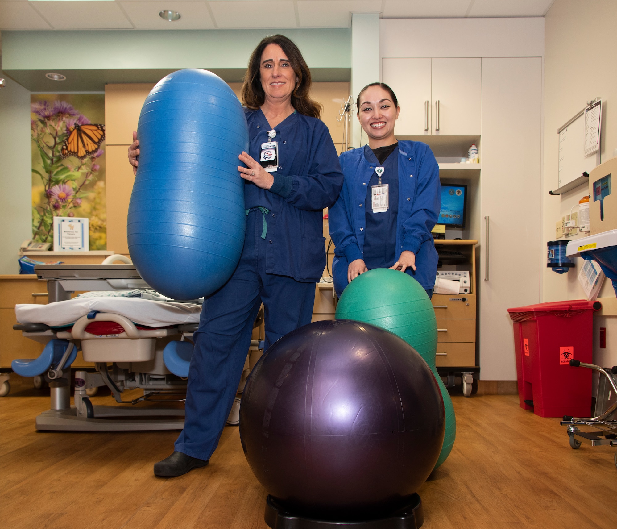 Joani Claxton, 60 Medical Group, registered nurse, and Amy Payne, a contract certified nurse midwife, show off “peanut balls” in the David Grant USAF Medical Center labor and delivery unit Feb. 11, 2018, at Travis Air Force Base, California. The balls are offered to pregnant women as part of a study to determine if they can reduce labor time and the need for a cesarean section.  The Maternal Child Flight at David Grant USAF Medical Center at Travis Air Force Base, Calif., is scheduled to host an open house in the labor and delivery unit Feb. 23 from 9 a.m. to 1 p.m. Visitors will be able to tour the private and home-like suites, meet staff members, as well as certified nurse midwives. During the event, staff members will be available to discuss birthing options. Everyone is invited to attend, including families and visitors will be eligible for prizes and souvenirs. (U.S. Air Force Photo by Heide Couch)