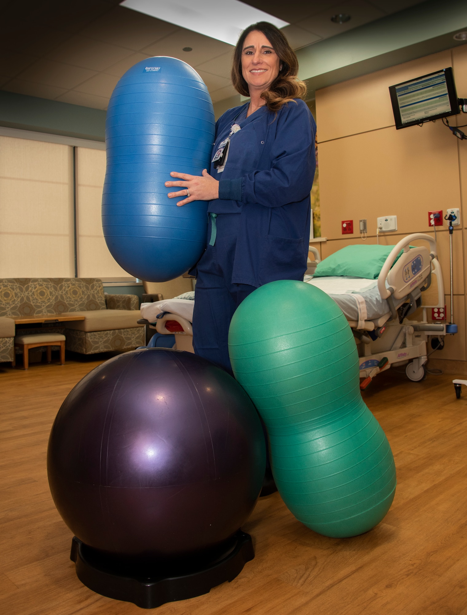 Joani Claxton, 60 Medical Group, registered nurse, shows off “peanut balls” in the David Grant USAF Medical Center labor and delivery unit Feb. 11, 2018, at Travis Air Force Base, California. The balls are offered to pregnant women as part of a study to determine if they can reduce labor time and the need for a cesarean section.  The Maternal Child Flight at David Grant USAF Medical Center at Travis Air Force Base, Calif., is scheduled to host an open house in the labor and delivery unit Feb. 23 from 9 a.m. to 1 p.m. Visitors will be able to tour the private and home-like suites, meet staff members, as well as certified nurse midwives. During the event, staff members will be available to discuss birthing options. Everyone is invited to attend, including families and visitors will be eligible for prizes and souvenirs. (U.S. Air Force Photo by Heide Couch)