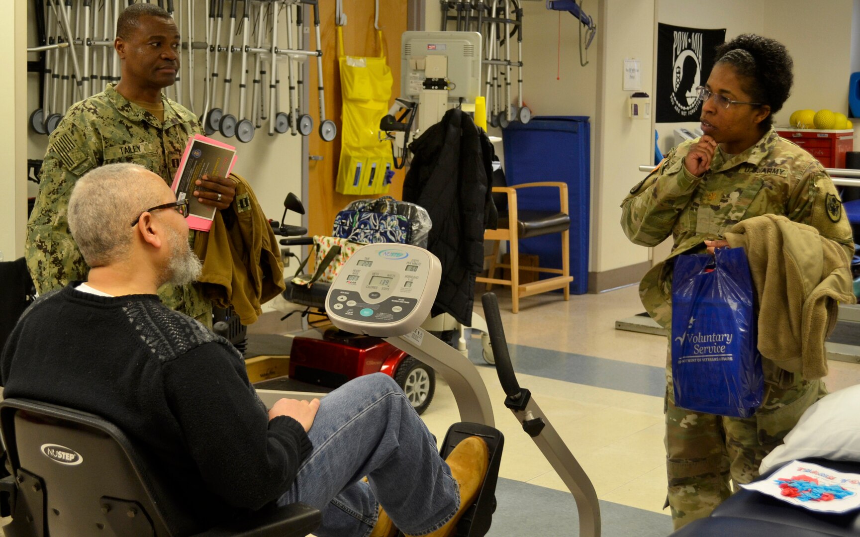 Army Maj. Andrea Jackson, a Medical division chief, right, and Navy Lt. Prince Tailey, a Medical branch chief, top left, listen to a patient receiving therapy care at the Corporal Michael J. Crescenz Veterans Affairs Medical Center, Feb. 11, 2019 in Philadelphia.
