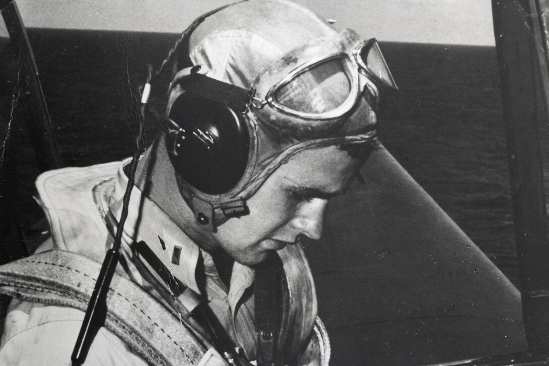 A man sits and takes notes in the cockpit of an airplane.