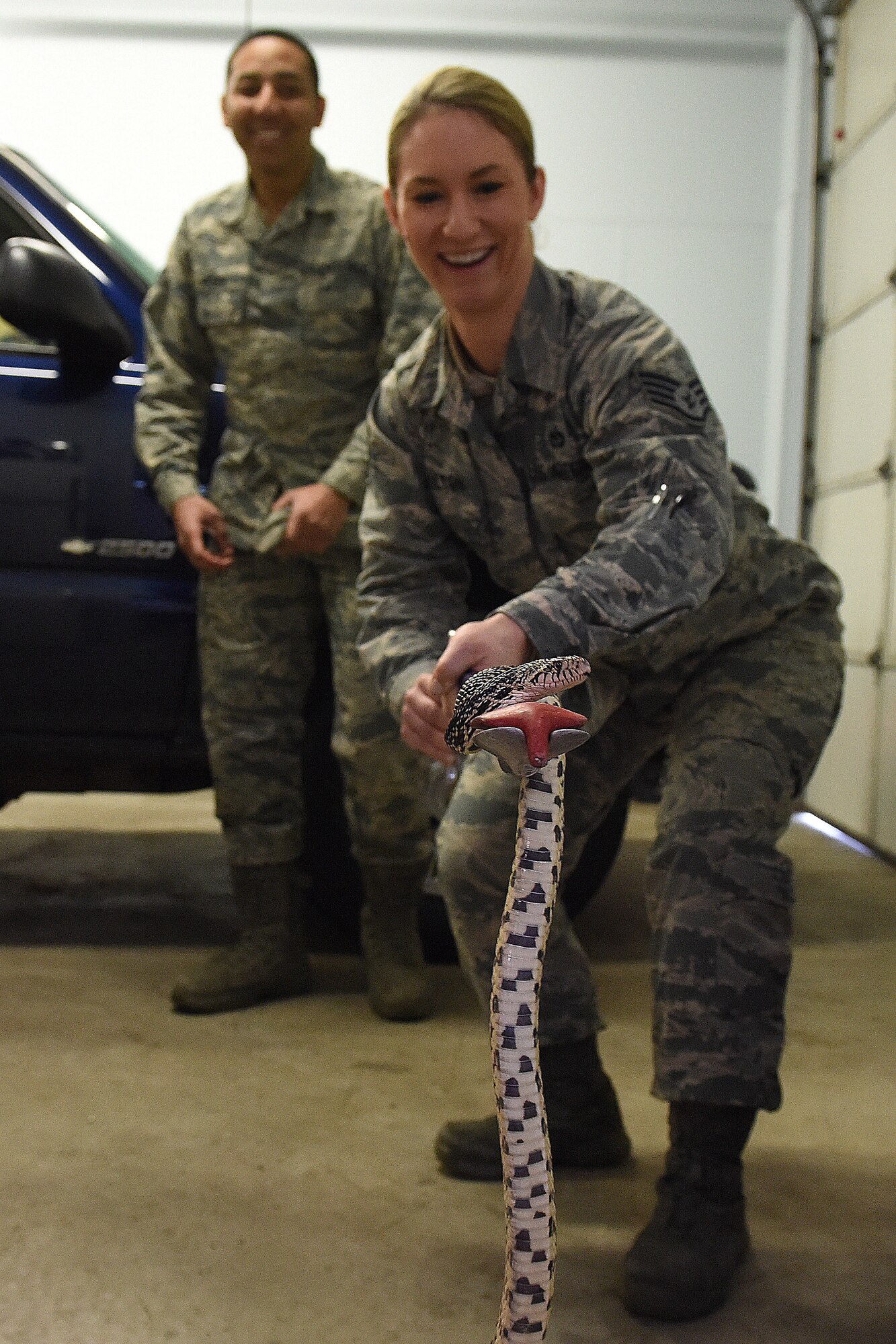 Staff Sgt. Kelly Hamilton, 341st Civil Engineer Squadron pest management craftsman, simulates catching a snake Feb. 13, 2019, at Malmstrom Air Force Base, Mont.