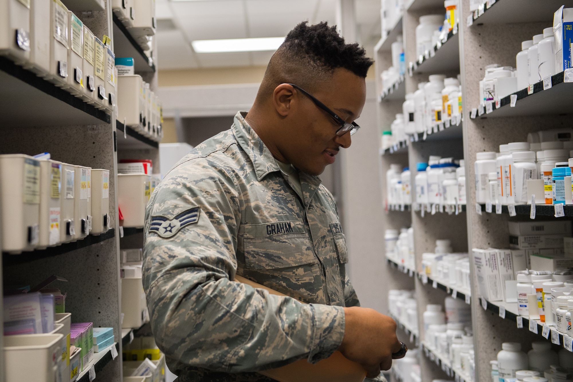 Senior Airman Franklin Graham, 2nd Medical Group Satellite Pharmacy technician, restocks shelves at Barksdale Air Force Base, La., Feb. 5, 2019. The pharmacy process 300 to 400 new prescriptions and 400 to 500 refills every day. (U.S. Air Force photo by Senior Airman Cassandra Johnson)