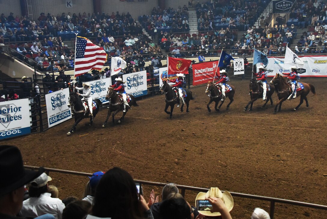 The San Angelo Stock Show and Rodeo Ambassadors Drill Team perform during the Annual San Angelo Stock Show and Rodeo Military Appreciation Night at the Foster Communications Coliseum in San Angelo, Texas, Feb. 13, 2019. They carried patriotic flags during the drill. (U.S. Air Force photo by Airman 1st Class Zachary Chapman/Released)