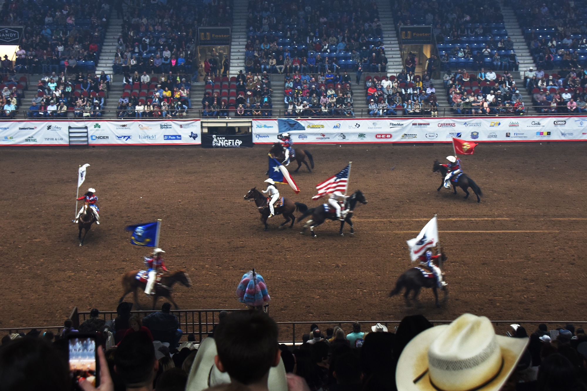 The San Angelo Stock Show and Rodeo Ambassadors Drill Team perform during the Annual San Angelo Stock Show and Rodeo Military Appreciation Night at the Foster Communications Coliseum in San Angelo, Texas, Feb. 13, 2019. They carried patriotic flags during the drill. (U.S. Air Force photo by Airman 1st Class Zachary Chapman/Released)