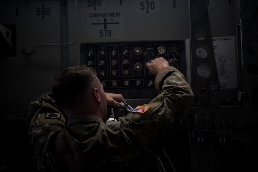 Army Spc. Tristan Sutherland, 50th Expeditionary Signal Battalion satellite communications operator, plugs a communication cable into a C-17 Globemaster III Feb. 7, 2019, at Joint Base Charleston, S.C.