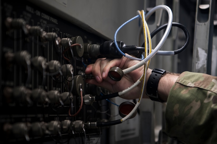 Army Spc. Tristan Sutherland, 50th Expeditionary Signal Battalion satellite communications operator, plugs a communication cable into a C-17 Globemaster III Feb. 7, 2019, at Joint Base Charleston, S.C.