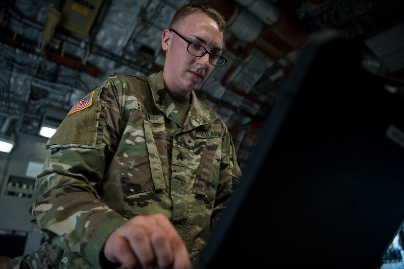 Army Sgt. William Suehn, 50th Expeditionary Signal Battalion key leader enroute node team chief, sets up communications systems in a C-17 Globemaster III Feb. 7, 2019, at Joint Base Charleston, S.C.