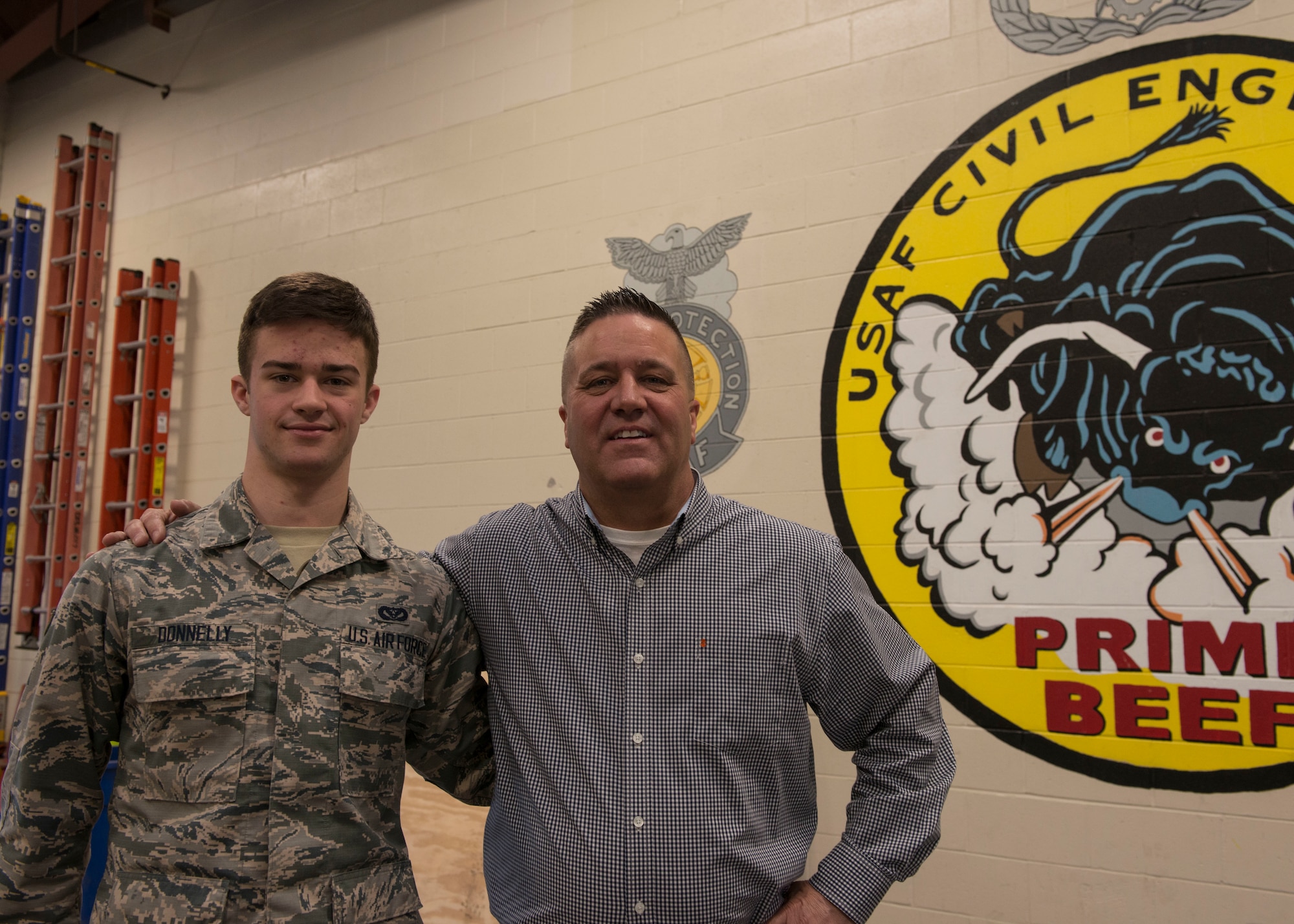 Airman 1st Class John Donnelly, III poses of the 103rd Civil Engineer Squadron poses for a photo with his father, Master Sgt. (Ret.) John Donnelly, II, February 10, 2019 at Bradley Air National Guard Base, East Granby, Conn. The senior Donnelly, an OSHA Federal Compliance Officer, coordinated with members of 103rd CES to conduct OSHA training for 40 members of the squadron. (U.S. Air National Guard photo by Tech. Sgt. Tamara R. Dabney)