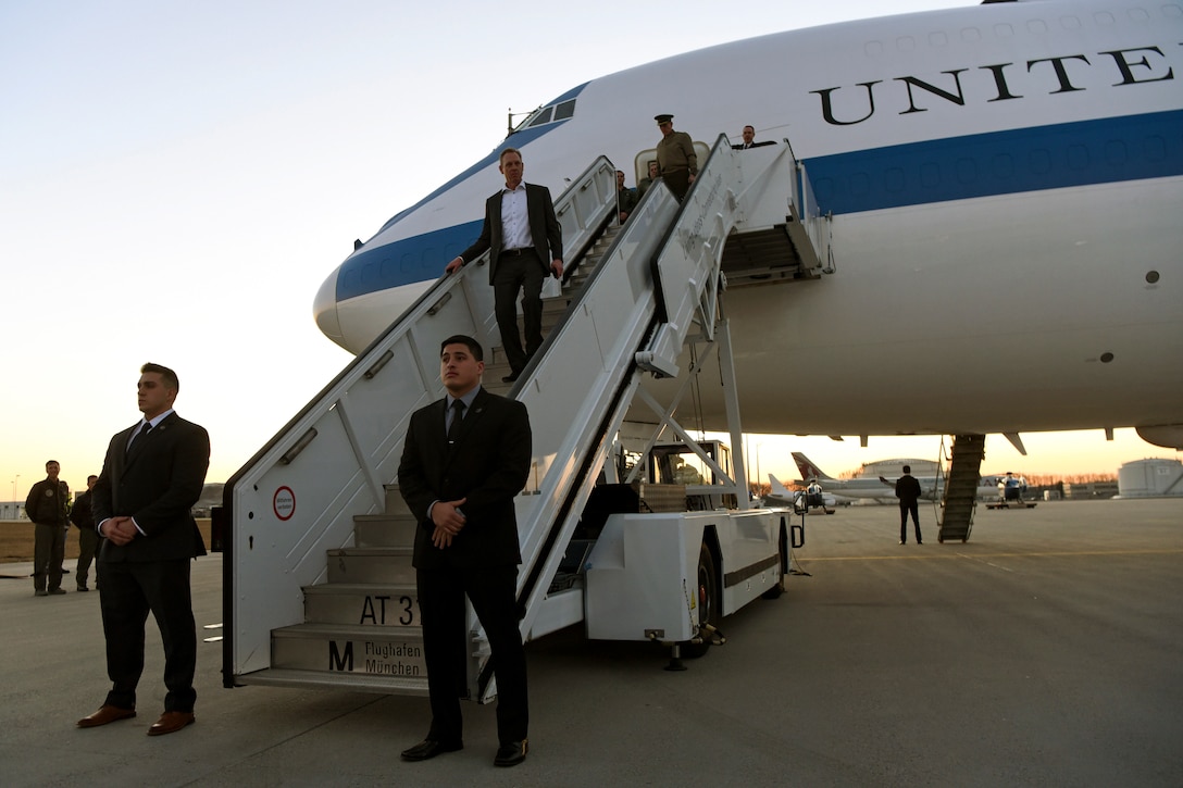 Acting Defense Secretary Patrick M. Shanahan walks down steps of a plane.