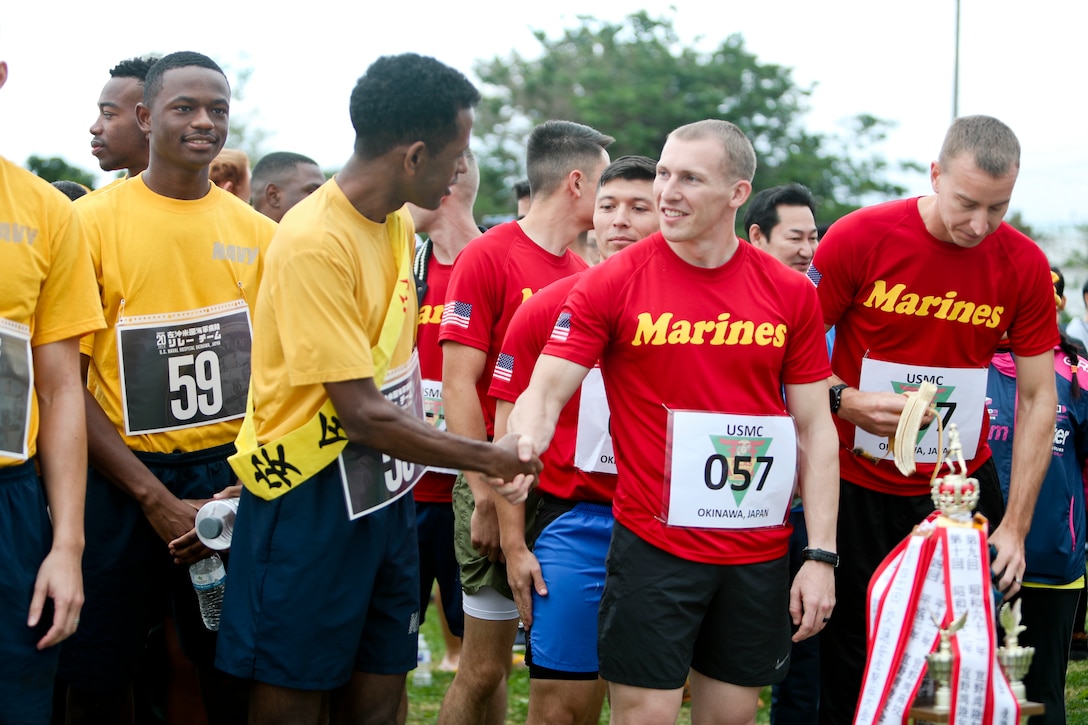 U.S. service members shake hands before the 42nd Ginowan Traffic Safety Relay Race at Marine Corps Air Station Futenma, Okinawa, Japan, Jan. 19, 2019. The race was held to bring awareness to the importance of traffic rules. (U.S. Marine Corps photo by Lance Cpl. Savannah Mesimer)