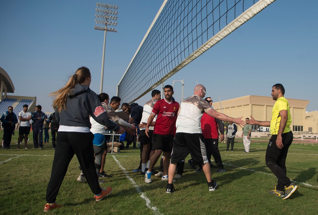 Qatar Emiri Air Force and U.S. Air Force members shake hands after finishing a volleyball match during Qatari National Sports Day Feb. 12, 2019, at Al Udeid Air Base, Qatar. U.S. and Qatar military forces were able to compete in team events including basketball, volleyball and soccer, as well as individual events such as swimming and ping pong throughout the morning. Qatari National Sports Day provided servicemembers from both nations an opportunity to strengthen military relations through friendly competition. (U.S. Air Force photo by Tech. Sgt. Christopher Hubenthal)