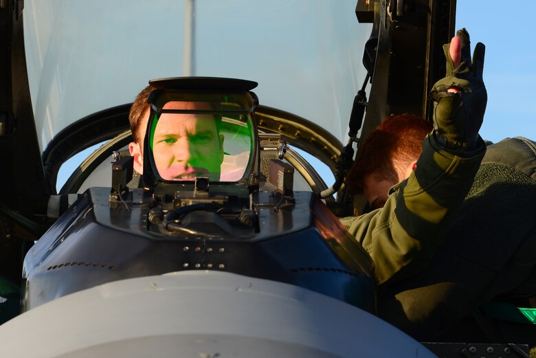A pilot gives a hand signal during a preflight walk
