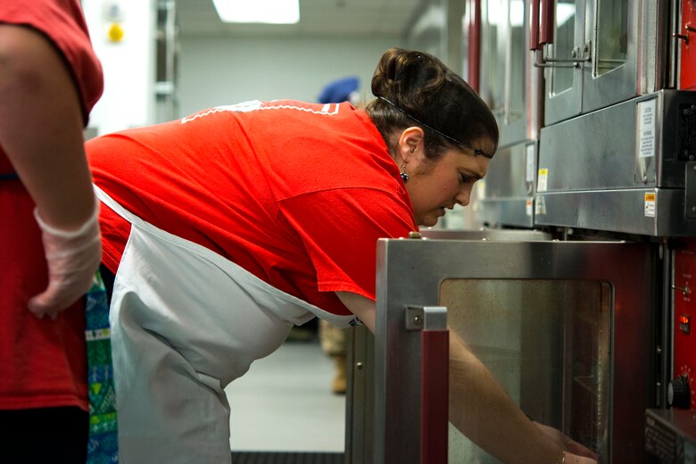 Heather Brooks, contestant, places her cake into an oven during the first Cupid Cake Wars, Feb. 13, 2019, at Moody Air Force Base, Ga. The event consisted of contestants working together in teams to create, bake and design their most inspired Valentine’s Day-themed cakes. (U.S. Air Force photo by Airman 1st Class Erick Requadt)