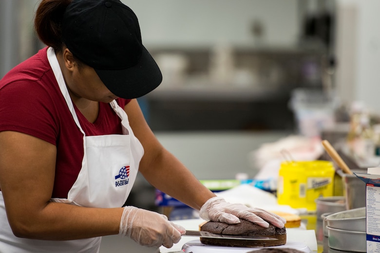 Jessica Johnson, contestant, cuts one of her cakes used for their design during the first Cupid Cake Wars, Feb. 13, 2019, at Moody Air Force Base, Ga. The event consisted of contestants working together in teams to create, bake and design their most inspired Valentine’s Day-themed cakes. (U.S. Air Force photo by Airman 1st Class Erick Requadt)