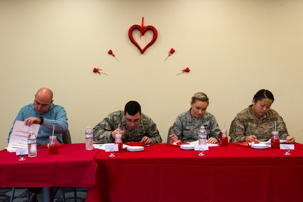 Judges score one of the cakes during the first Cupid Cake Wars, Feb. 13, 2019, at Moody Air Force Base, Ga. The event consisted of contestants working together in teams to create, bake and design their most inspired Valentine’s Day-themed cakes. (U.S. Air Force photo by Airman 1st Class Erick Requadt)