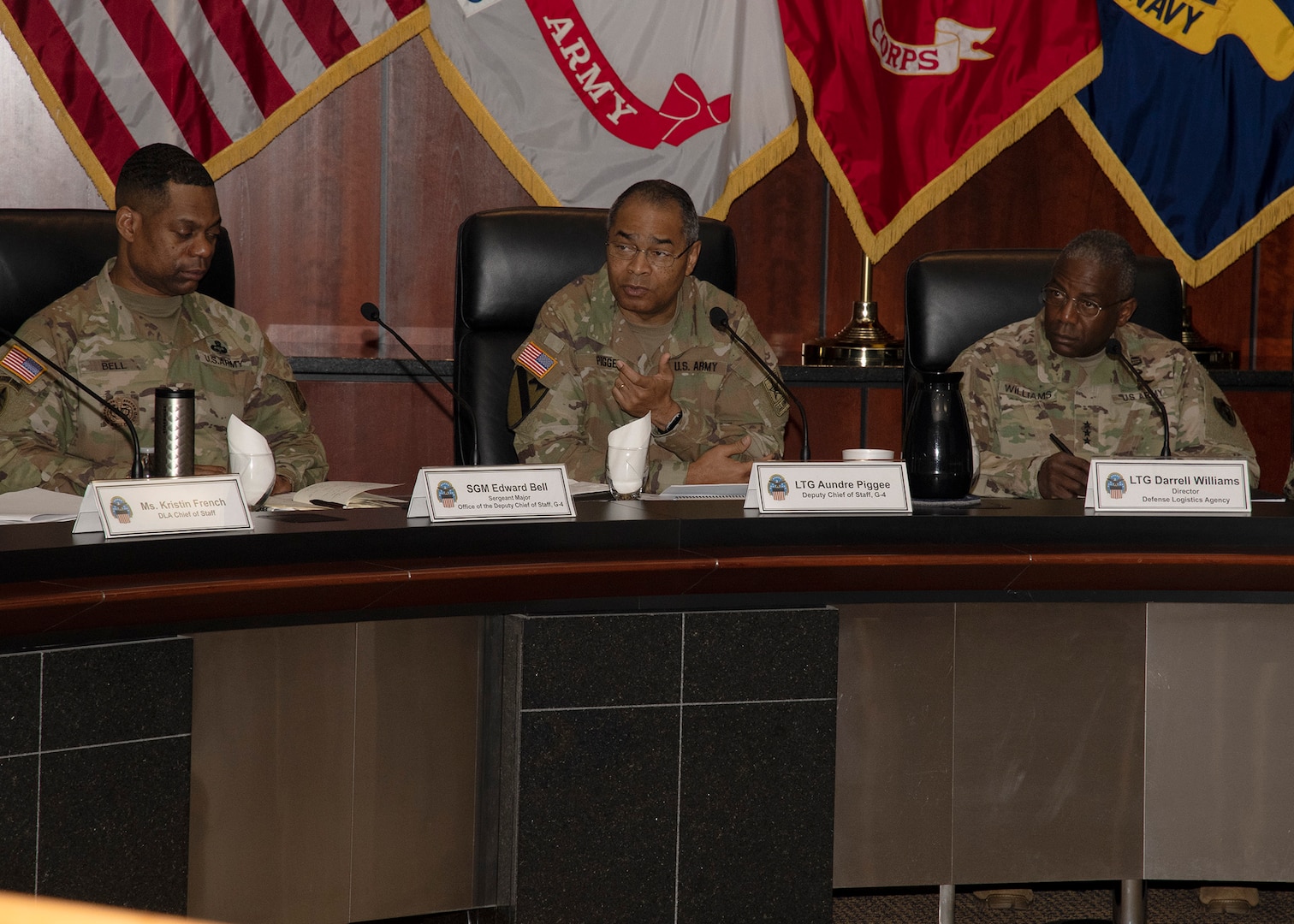 Three Army logisticians sit talking.