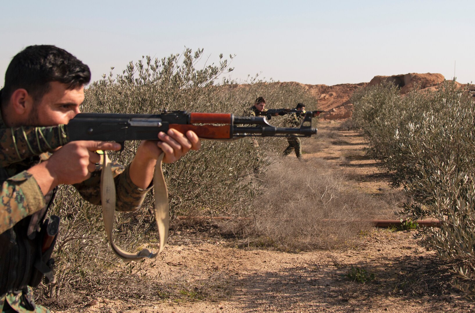 Syrian Democratic Forces troops assault through a target objective during a react-to-contact training event in Deir el-Zour province, Syria.