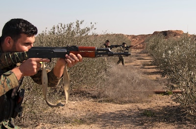 Syrian Democratic Forces troops assault through a target objective during a react-to-contact training event in Deir el-Zour province, Syria.