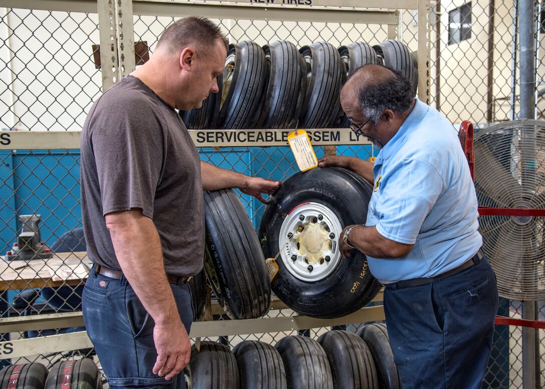 Gary Harris, 12th Flying Training Wing aerospace ground equipment mechanic, and Roy Spencer, 12th Maintenance Group Aircraft Wheel and Tire Shop technician, inspect a T-1 wheel at the Aircraft Wheel and Tire Shop on Feb. 14, 2019, at Joint Base San Antonio-Randolph, Texas. Tire shop technicians and AGE members are part of a team that ensure the integrity of the wheels and tires used on the 12th FTW’s fleet of trainer aircraft. (U.S. Air Force photo by Tech. Sgt. Ave I. Young)