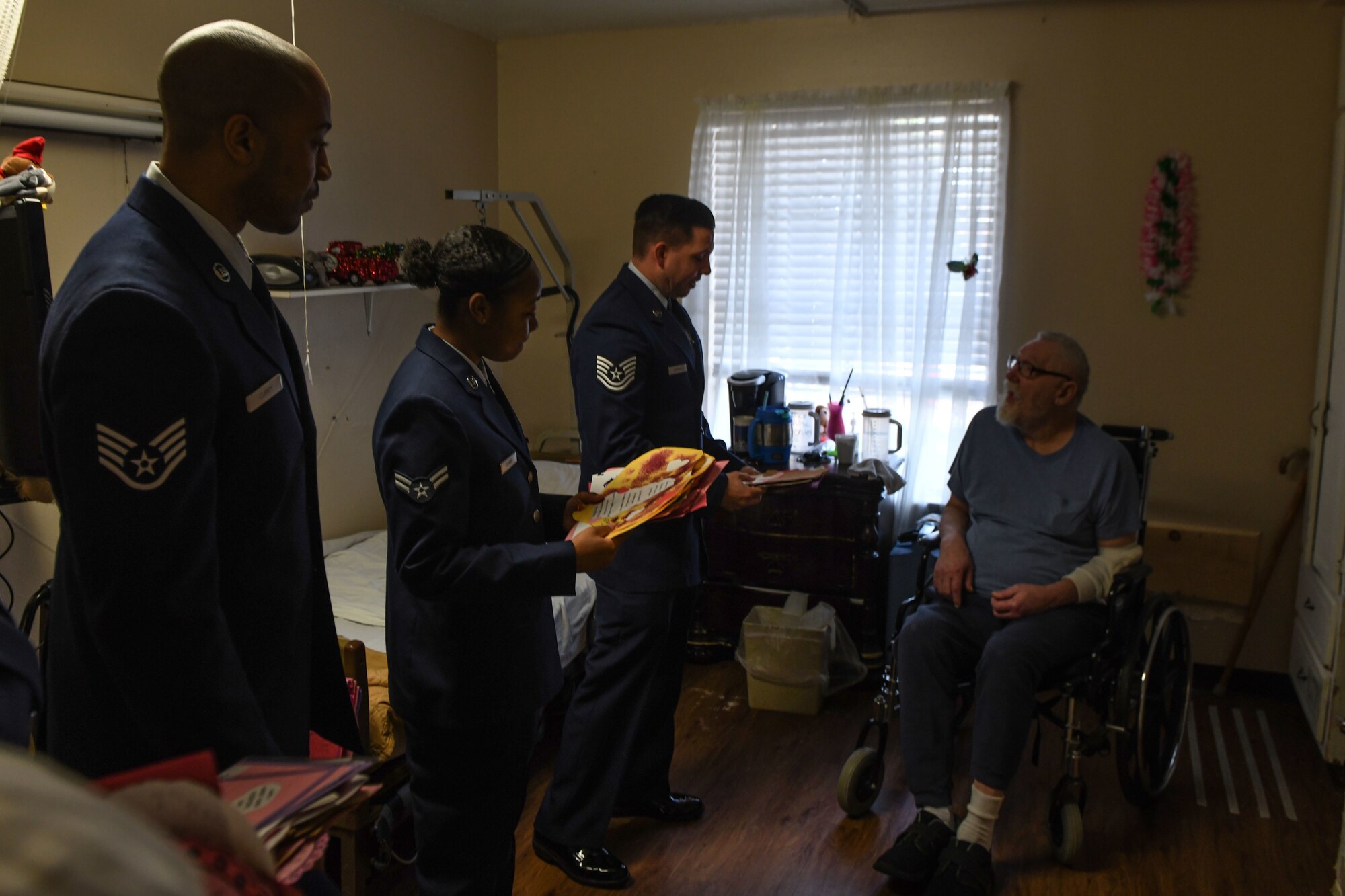 Airmen assigned to the 97th Air Mobility Wing talk with two veterans after giving them Valentine’s Day cards,