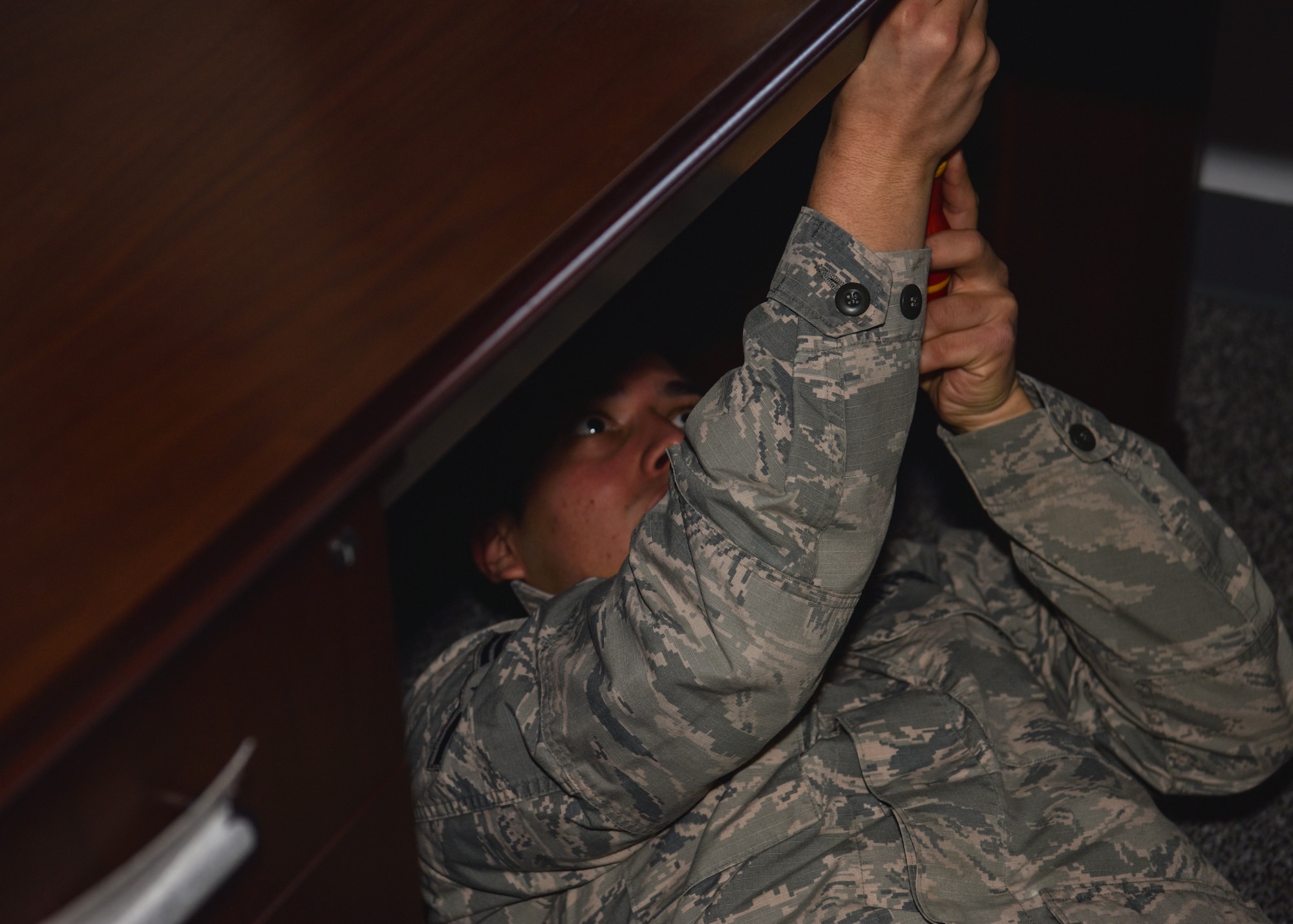 Airman 1st Class Jaelviaser Castro-Escobar, 90th Missile Maintenance Squadron missile handling technician, drives a screw into a desk, Feb. 4, 2019, on F.E. Warren Air Force Base, Wyo. The 90th MMXS was selected as one of the recipients of the innovation funds from the Warren Shootout. The squadron recently renovated six storage closets and turned them into functioning offices. (U.S. Air Force photo by Airman 1st Class Braydon Williams)