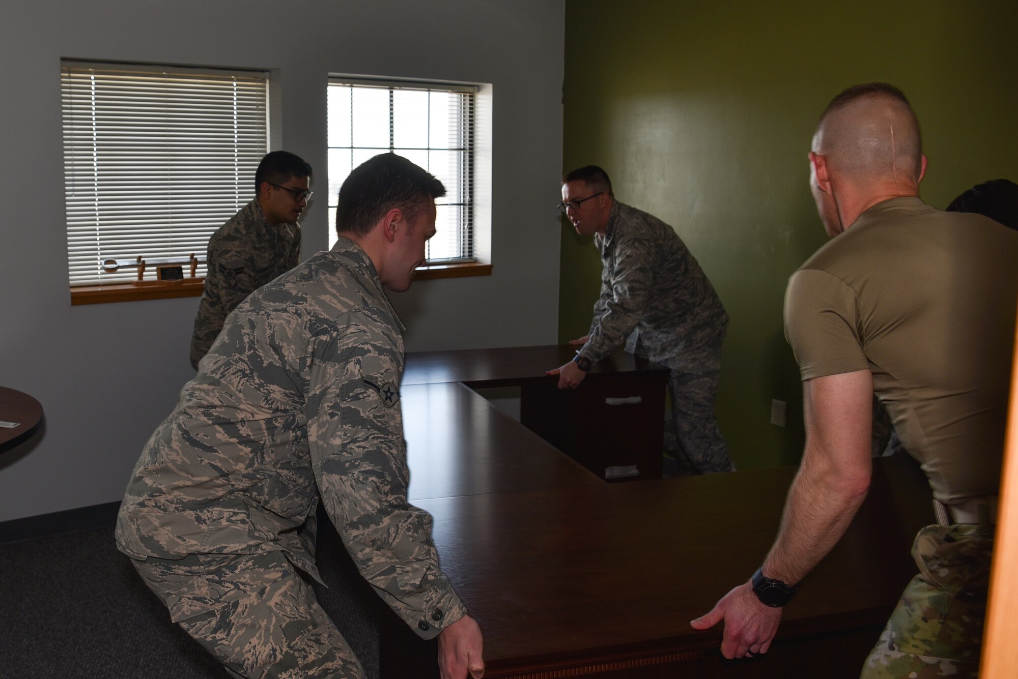 Airmen with the 90th Maintenance Group move a desk in a newly renovated office, Feb. 4, 2019, on F.E. Warren Air Force Base, Wyo. The 90th Missile Maintenance Squadron was selected as one of the recipients of the innovation funds from the Warren Shootout. The squadron recently renovated six storage closets and turned them into functioning offices. (U.S. Air Force photo by Airman 1st Class Braydon Williams)