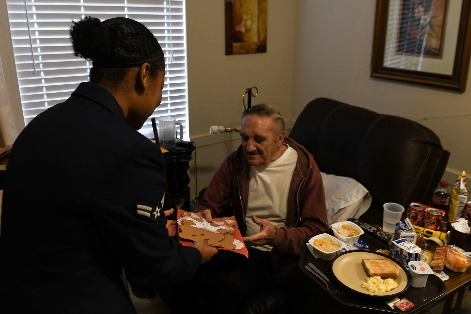 Airman 1st Class Hope Curry, material management specialist assigned to the 97th Logistics Readiness Squadron, hands Valentine’s Day cards to a veteran