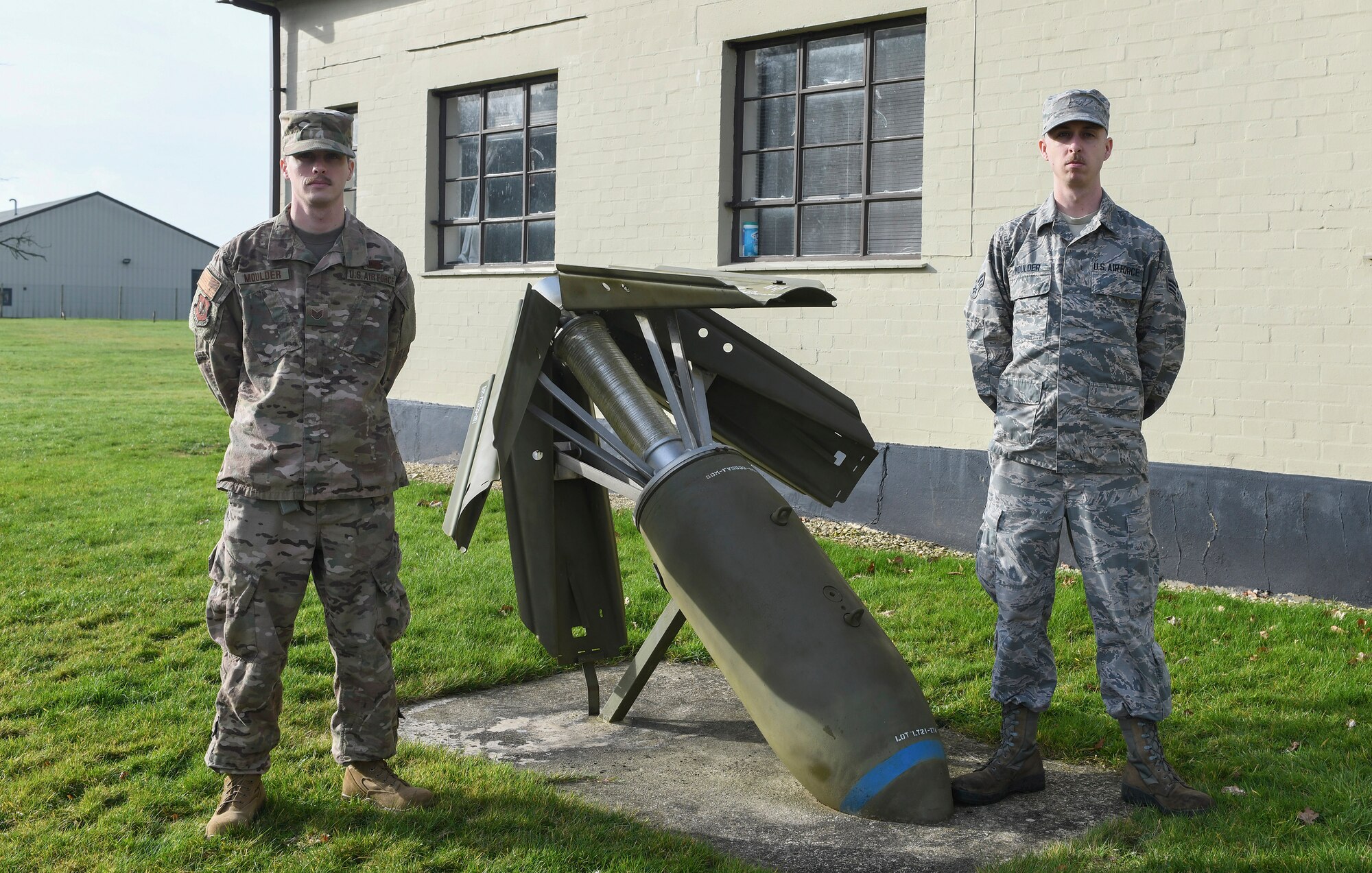 U.S. Air force Staff Sgt. Damian Moulder, 420th Munitions Squadron, and Senior Airman Cory Moulder, 420MUNS, stand next to a static bomb display at RAF Welford, United Kingdom, Feb. 13, 2019. The two are brothers and are being highlighted by the 501st Combat Support Wing for their rare and unique situation of being stationed together in the same unit. (U.S. Air Force photo by Senior Airman Chase Sousa)
