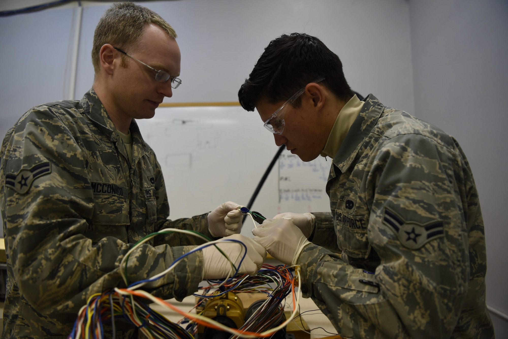 Airman 1st Class John Mcconnico and Airman 1st Class Wilfredo Hernandez Mendez, 90th Missile Maintenance Squadron Hardened Intersite Cable System technicians, train to splice together a wire within a larger cable Jan. 31, 2019, at F.E. Warren Air Force Base, Wyo. The 90th MMXS HICS team maintains the upkeep and repair of the cables throughout the missile field. The cables run throughout the F.E. Warren Missile Complex and are part of the communication system between launch control centers and an ICBM at a launch facility. (U.S. Air Force photo by Senior Airman Abbigayle Williams)
