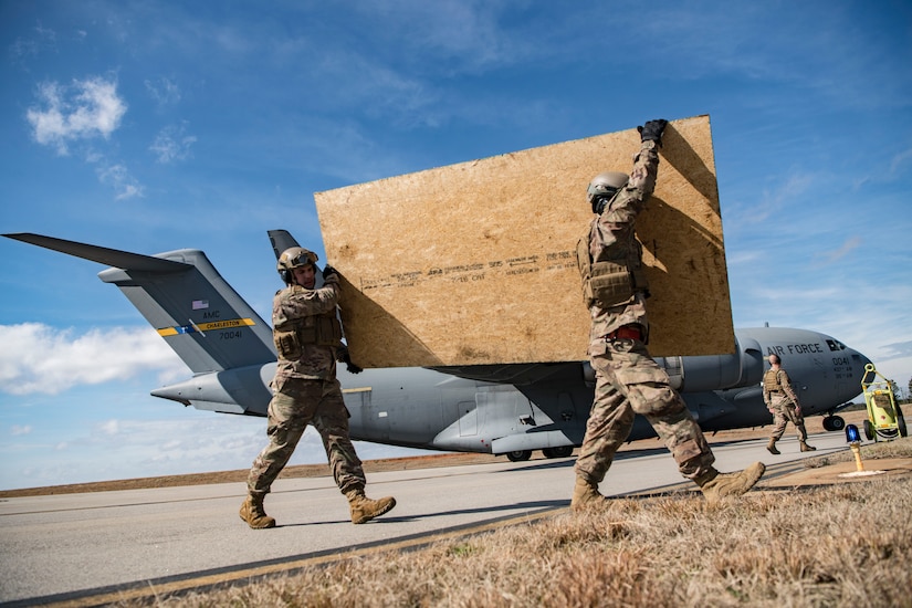 Airmen from the 621st Contingency Response Squadron offload plywood from a C-17 Globemaster III during Exercise Crescent Moon Feb. 12, 2019, at North Auxiliary Airfield in North, S.C.