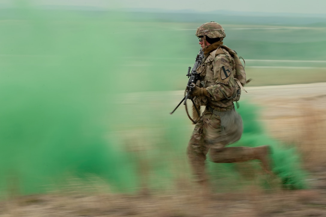An service member runs during a live-fire exercise.